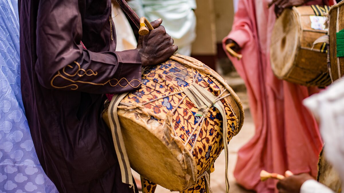 Percussionist playing hand drums under warm stage lights