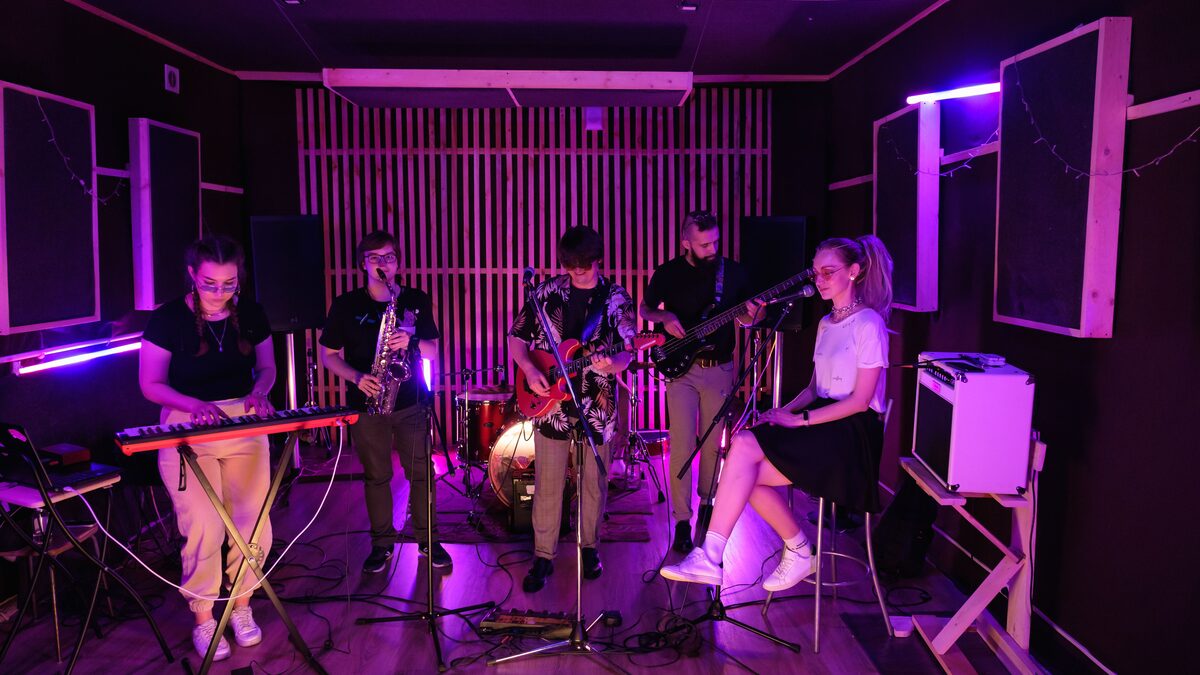 A group of musicians writing ideas on a whiteboard in a rehearsal space