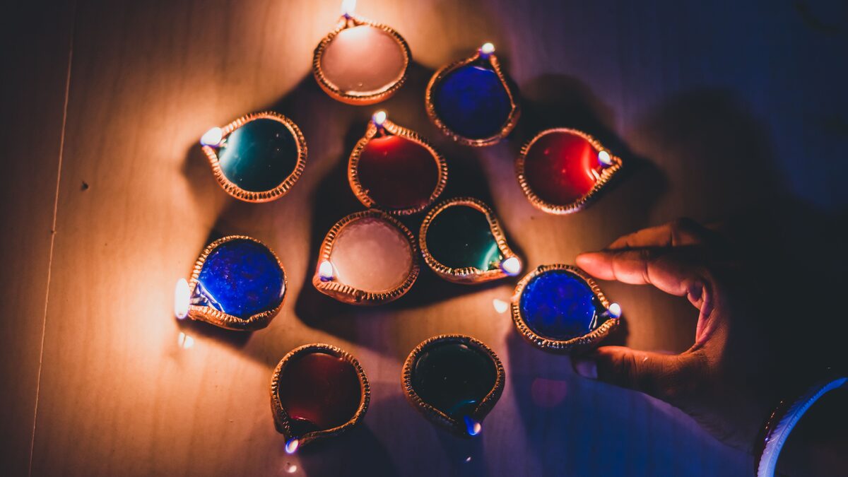 Row of glowing diyas and marigold flowers arranged for a Diwali celebration