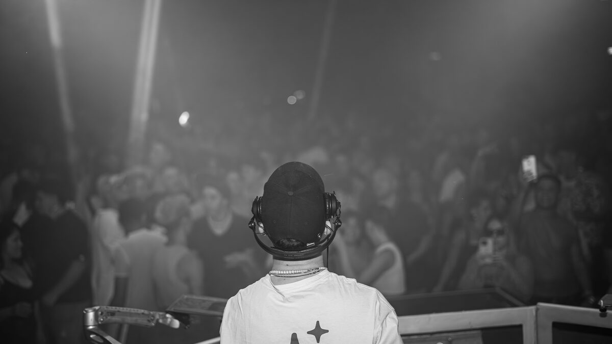 a DJ performing to a crowd in a dark club