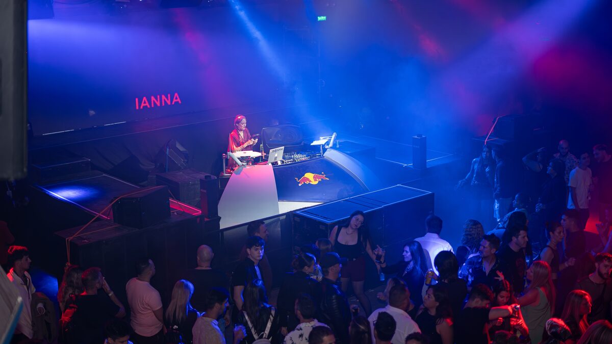 A dark club dancefloor lit by blue and pink lights