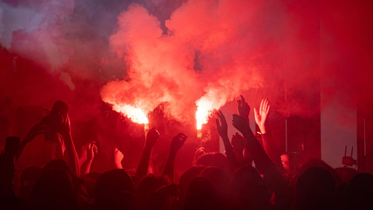A crowded basement show with a blurred, energetic crowd in dim light