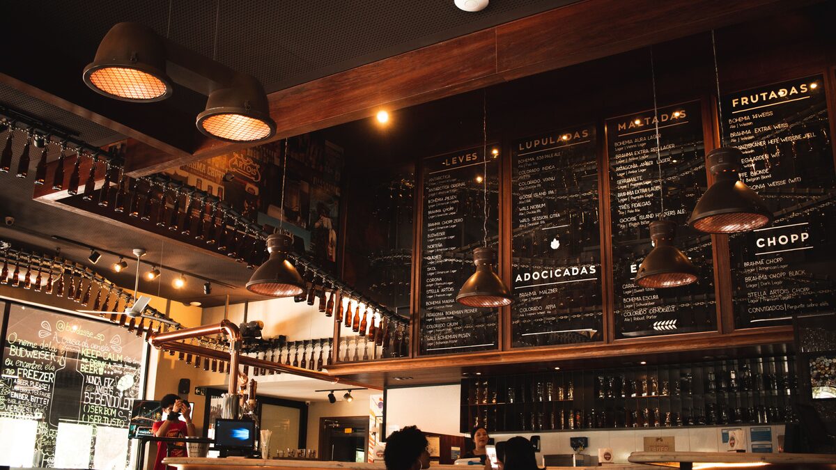 A cozy cafe interior with a small speaker on a shelf and soft lighting over tables