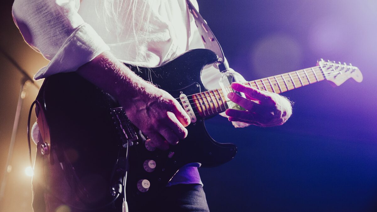 Electric guitar and amplifier on a dark stage under red lights
