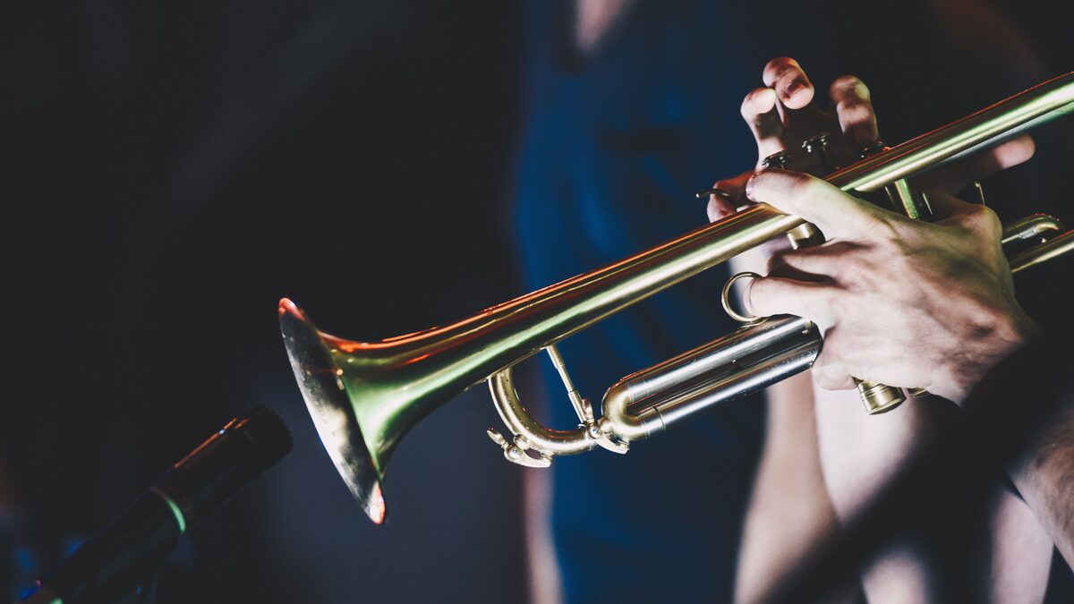 A brass section playing bright horns at a live ska show