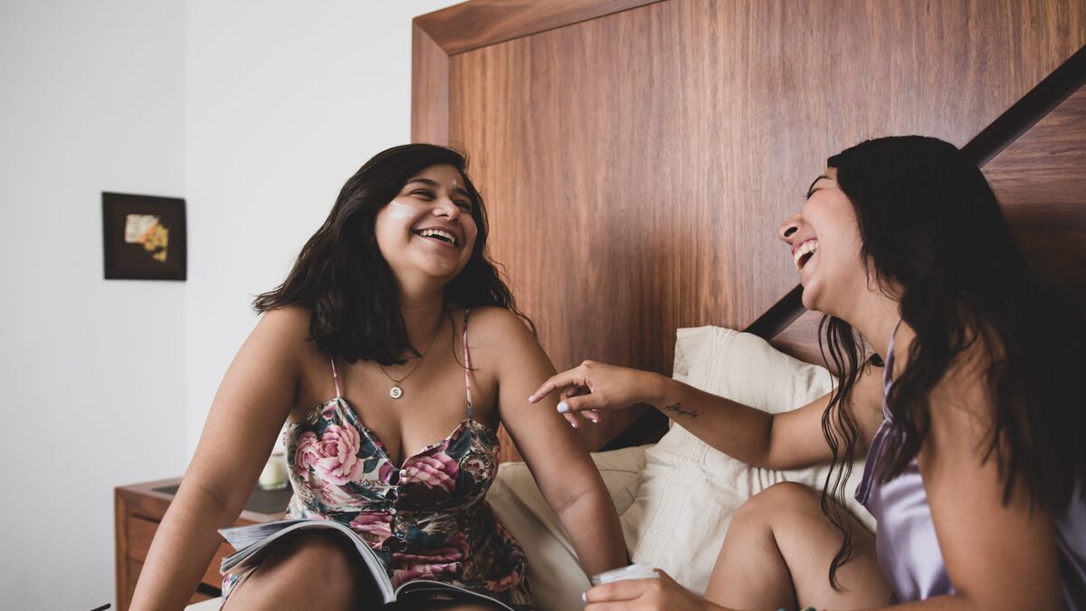 Two sisters laughing together outdoors