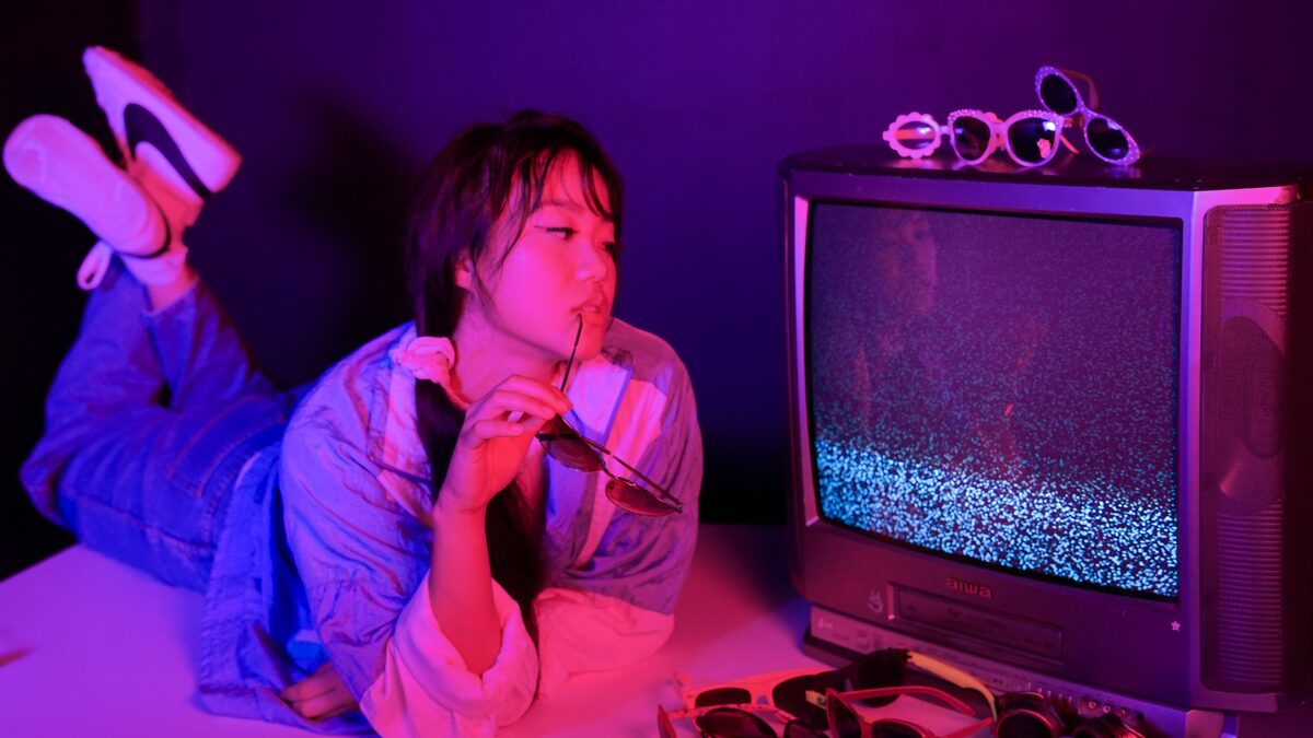 A neon-lit retro arcade with pink and purple glow evoking vaporwave aesthetics