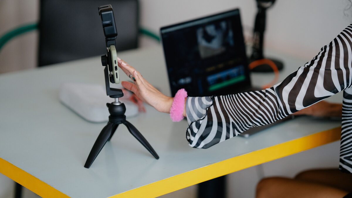 A video creator editing a YouTube video on a computer with an audio timeline visible