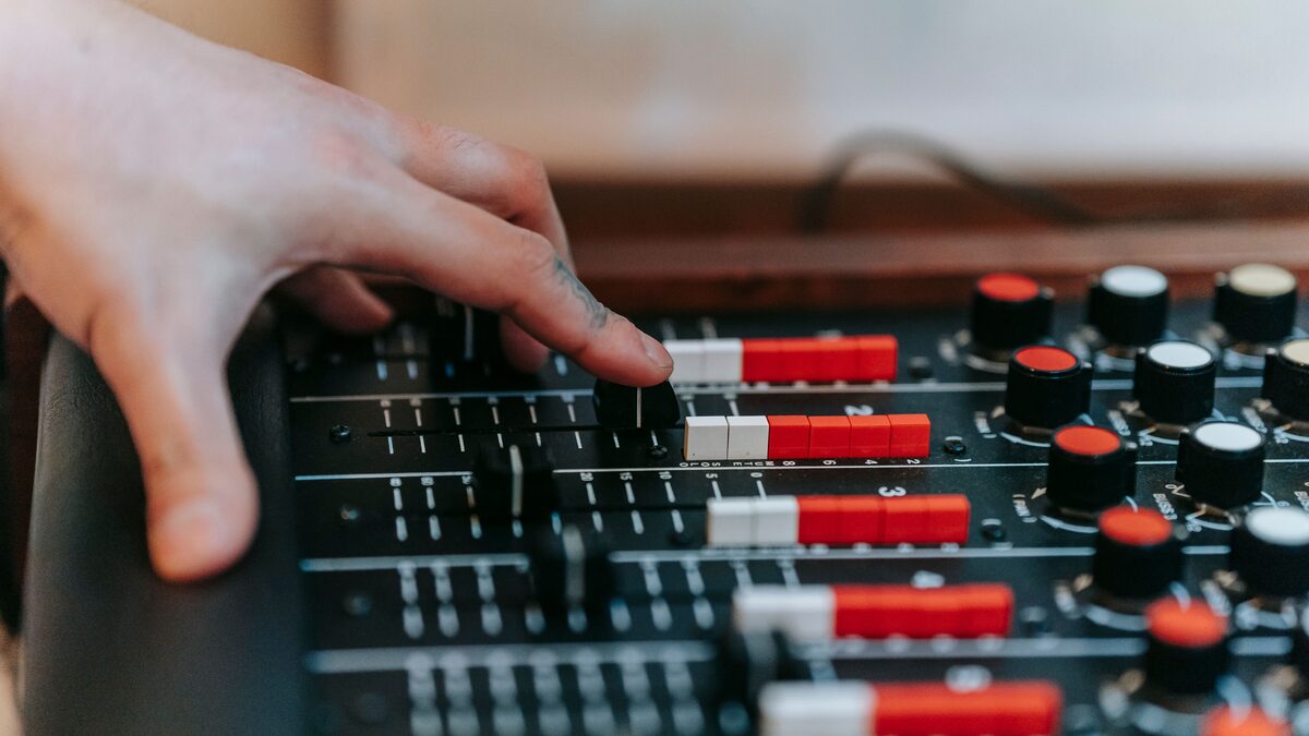 A person adjusting a volume fade on an audio waveform in an editor