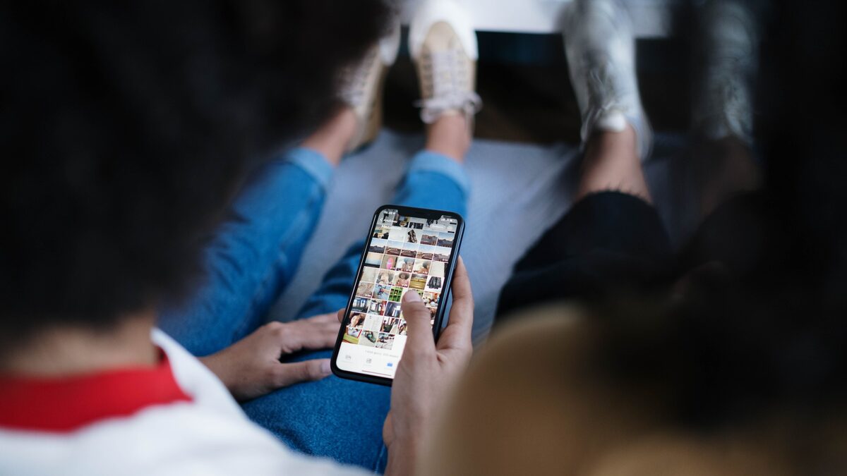 Person holding a phone showing a music player while sharing a song