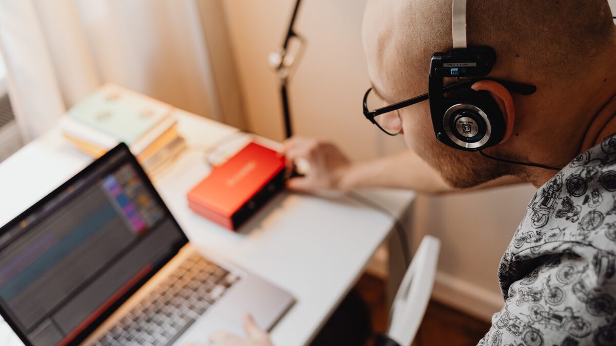 Making a song with AI on a laptop with headphones and audio gear
