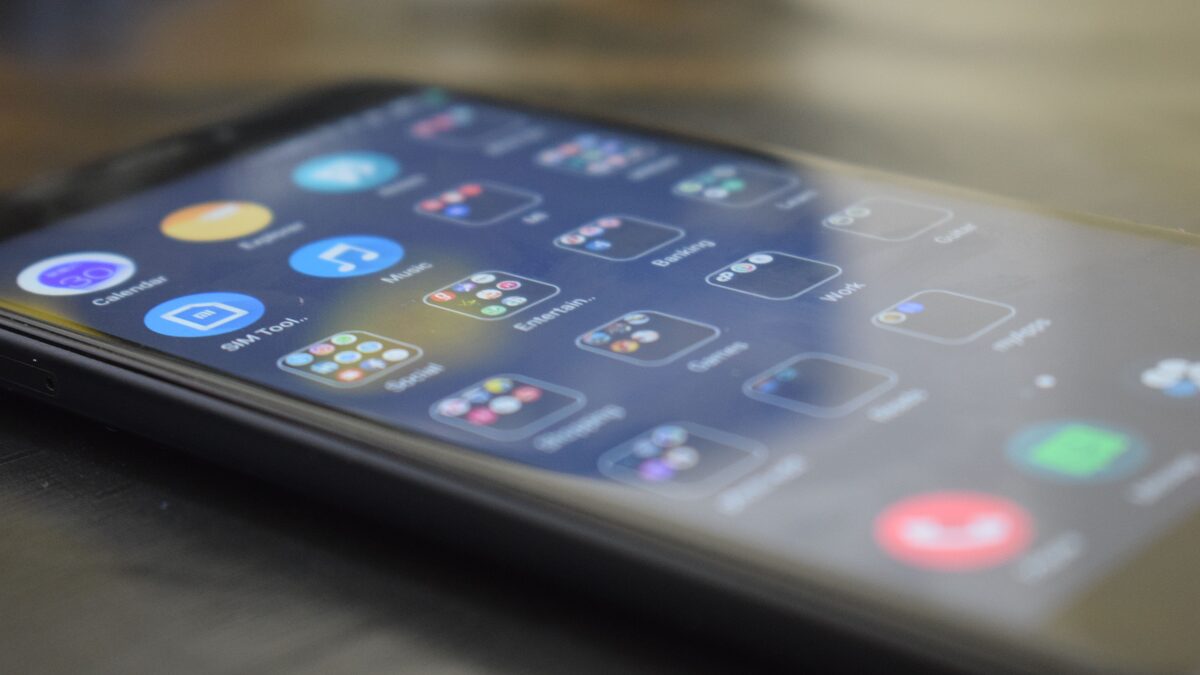 Two contrasting music apps open on a phone and a laptop