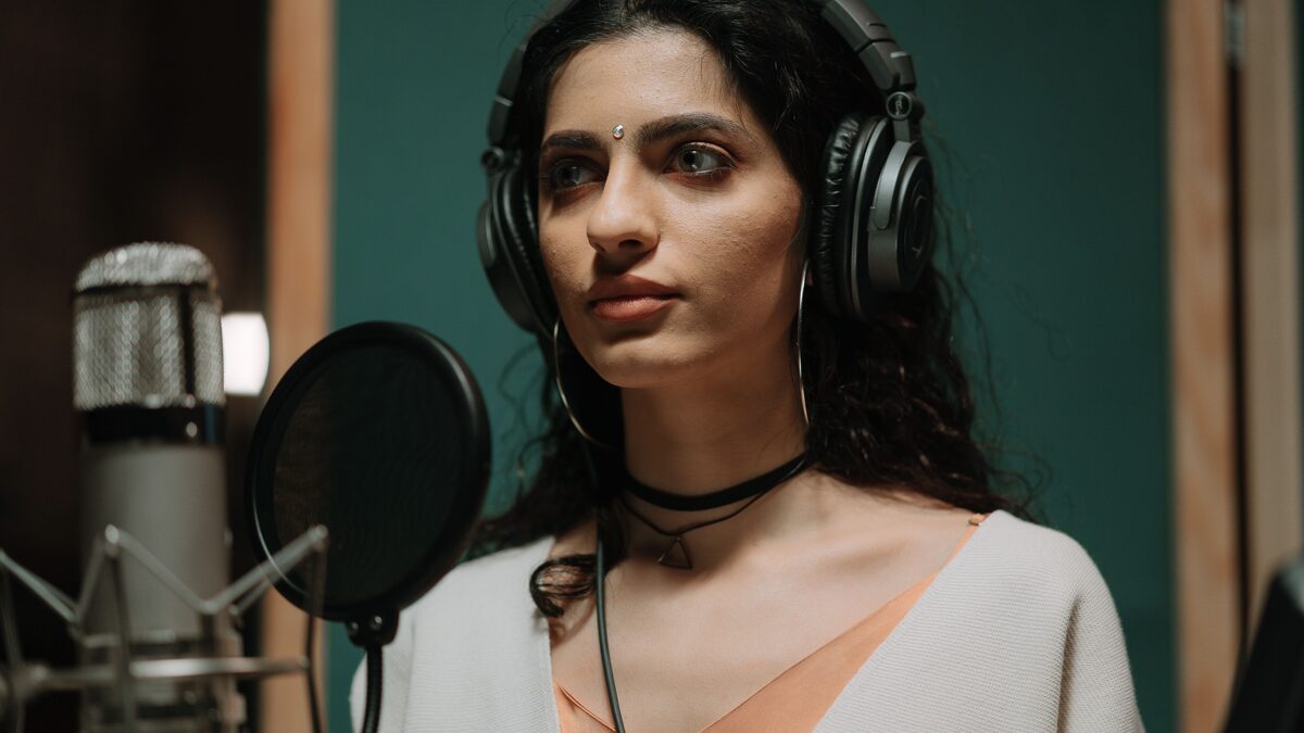 Singer recording vocals in a studio, illustrating a Udio review